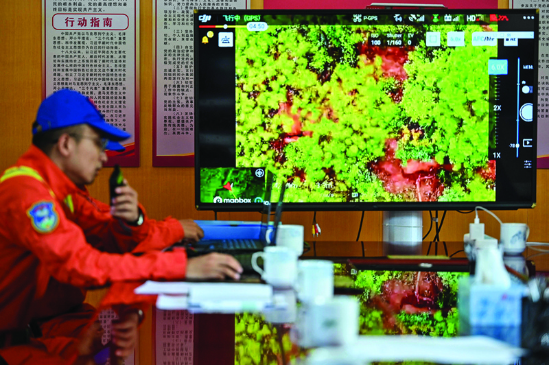 This picture shows a member of the Yunnan Forest Brigade monitoring a herd of migrating elephants from the command center in Daqiao in southwest China’s Yunnan province. — AFP photosn