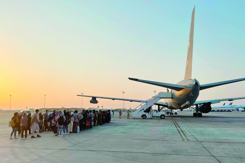 KUWAIT: This handout picture released by the Italian Defense press office yesterday shows passengers, who fled Afghanistan, boarding an Italian military aircraft at the Kuwait International Airport to fly to Rome. - AFPn