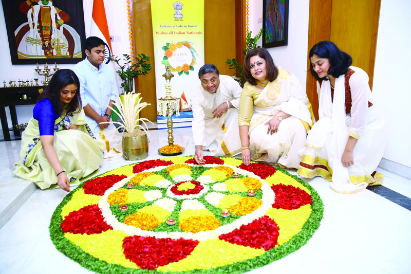 KUWAIT: Indian Ambassador Sibi George and family design a floral carpet at the India House, Indian embassy, yesterday.nn