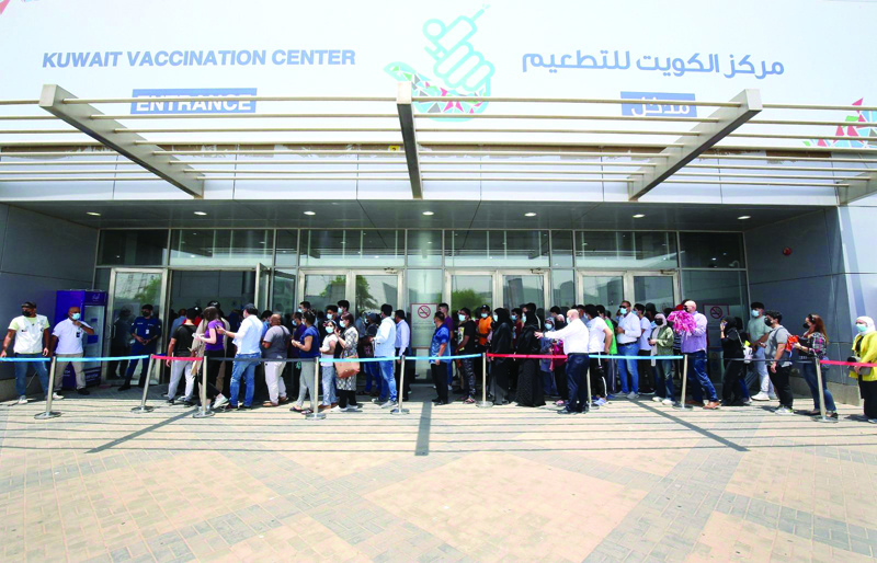 KUWAIT: This file photo taken on August 3, 2021 shows people lined up to receive their COVID-19 vaccines at the Kuwait Vaccination Center in Mishref. - Photo by Yasser Al-Zayyatn