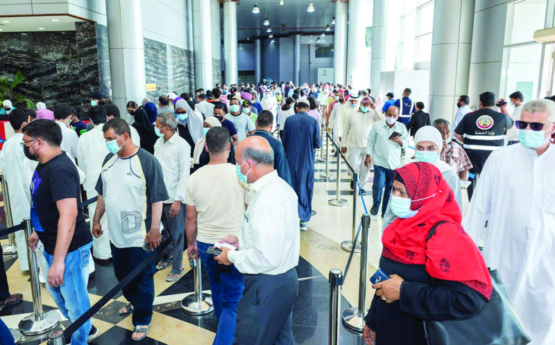 KUWAIT: A combination of photos released by Kuwait's health ministry showing people queuing to receive their COVID-19 vaccine jabs during the holiday. - KUNA photosn