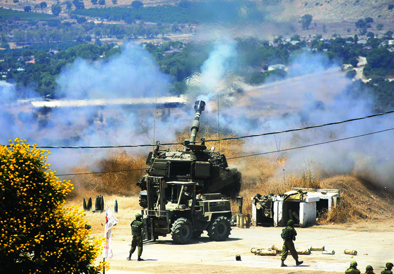 KIRYAT: Zionist regime's self-propelled howitzers fire towards Lebanon from the northern Jewish town of Kiryat Shmona yesterday.-AFPn