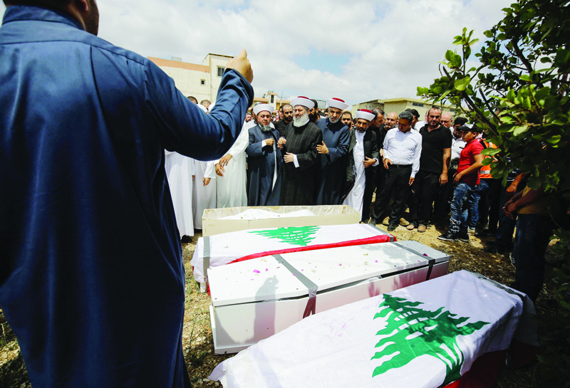 Prayers are recited during the funeral of four members of the Shraytih family in the village of Al-Daouseh yesterday. - AFP  n