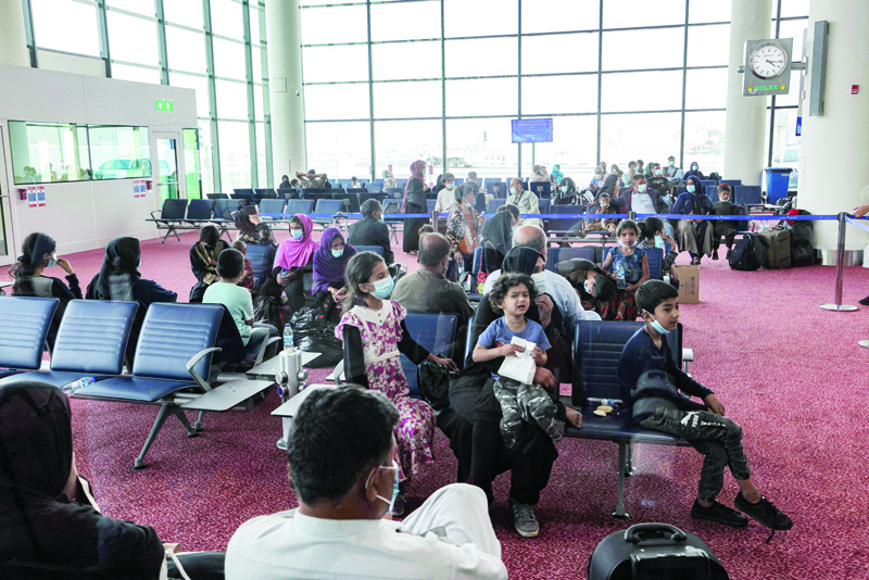 DUBAI: Evacuees from Afghanistan sit in a hall upon their arrival at Al-Maktoum International Airport in the United Arab Emirates yesterday. Britain's operation to evacuate its nationals and protected individuals stepped up, with planes landing in Dubai before passengers travel on to the UK. - AFPn