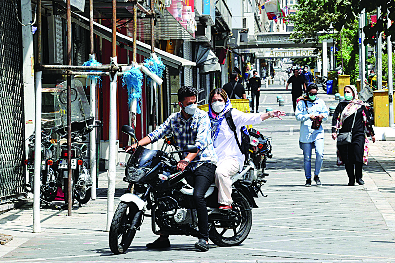 TEHRAN: Iranians commute past shuttered stores at Valiasr square in the capital Tehran, at the start of renewed restrictions for 5 days to mitigate the spread of the COVID pandemic. – AFPn