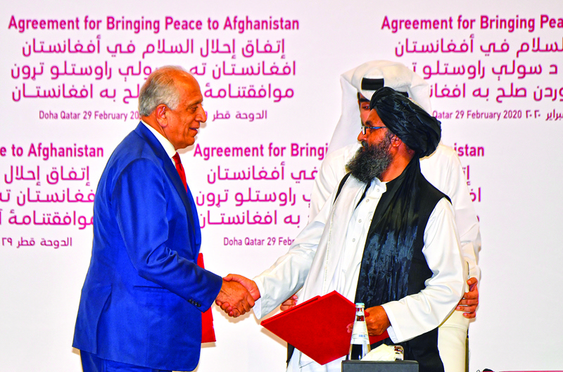 DOHA: In this file photo taken on February 29, 2020 (left to right) US Special Representative for Afghanistan Reconciliation Zalmay Khalilzad and Taleban co-founder Mullah Abdul Ghani Baradar shake hands after signing a peace agreement during a ceremony in the Qatari capital Doha. – AFPnnn