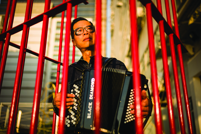 This file photo shows local artist Kacey Wong playing the accordion inside a red mobile prison artwork called 'The Patriot', a protest performance art project protesting against the National Anthem Law, at his studio in Hong Kong.  — AFP n