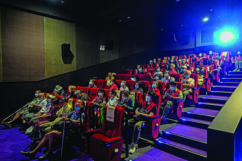 This photo shows visually impaired people listening to the film narrator during a screening at a cinema in Beijing.—AF photosn