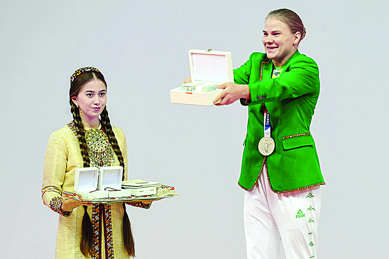 ASHGABAT: Turkmenistan's first-ever Olympic medalist, weightlifter Polina Guryeva (right) receives presents during a ceremony in the capital Ashgabat yesterday. - AFPn