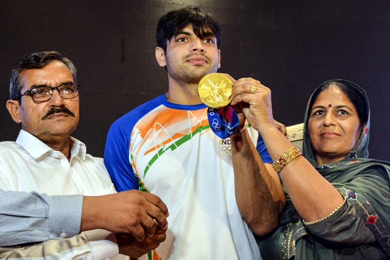 NEW DELHI: Gold medalist India's Neeraj Chopra (center) poses for pictures along with his parents at a press conference in New Delhi yesterday. – AFPn