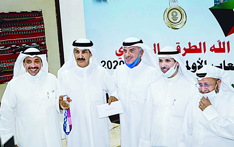 KUWAIT: Abdullah Al-Rashidi (second left) shows off his bronze medal during a ceremony the Kuwait Shooting Federation held on Tuesday to honor him following his return from Tokyo, Japan where he participated in the 2020 Olympics. - KUNAn