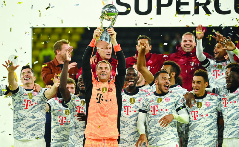 DORTMUND: Bayern Munich's German goalkeeper Manuel Neuer lifts the trophy after the German Super Cup football match against Borussia Dortmund in Dortmund on Tuesday. - AFPnn