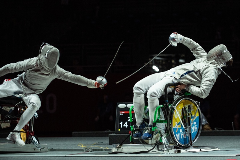 CHIBA: China's Li Hao (left) competes with Ukraine's Artem Manko during the men's sabre individual category A gold medal wheelchair fencing bout at the Tokyo 2020 Paralympic Games at the Makuhari Messe Hall in Chiba yesterday. - AFPn