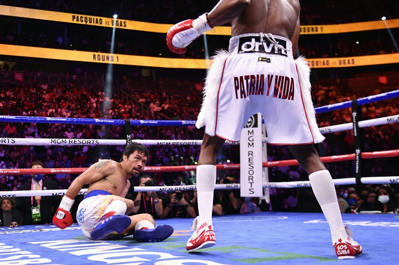 LAS VEGAS: Manny Pacquiao of the Philippines (left) looks at Yordenis Ugas of Cuba after being knocked down during the WBA Welterweight Championship boxing match at T-Mobile Arena in Las Vegas, Nevada on Saturday. - AFPn
