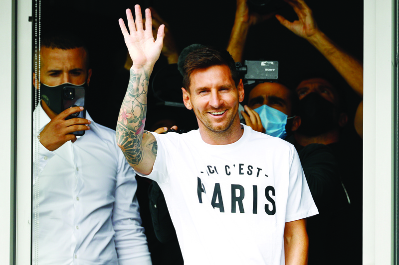 LE BOURGET: Argentinian football player Lionel Messi waves to supporters from a window after he landed yesterday at Le Bourget airport, north of Paris, as Paris Saint-Germain looked to complete the 34-year-old signing following his departure from Barcelona. - AFPnn