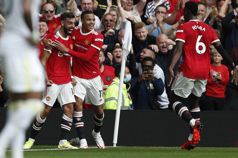 MANCHESTER: Manchester United's midfielder Bruno Fernandes (left) celebrates scoring his team's first goal with striker Mason Greenwood (center) and midfielder Paul Pogba during the English Premier League match against Leeds United at Old Trafford in Manchester, north west England yesterday. – AFPn