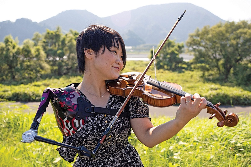 Japanese musician Manami Ito, who is also a qualified nurse and former Paralympic swimmer, plays the violin using her prosthetic arm during a photography session in Shizuoka. —AFP photos