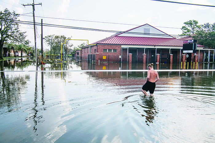 JEAN LAFITTE, Louisiana: A person wades through water while waiting for aid yesterday in Jean Lafitte, Louisiana. Jean Lafitte Mayor Tim Kerner has pleaded for help for residents of the small town, which is roughly 20 miles south of New Orleans. —AFP