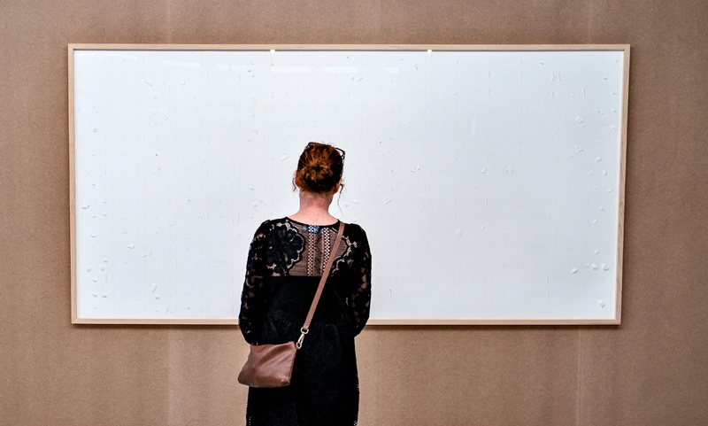 A woman stands in front of an empty frame hung up at the Kunsten Museum in Aalborg, Denmark.—AFP n
