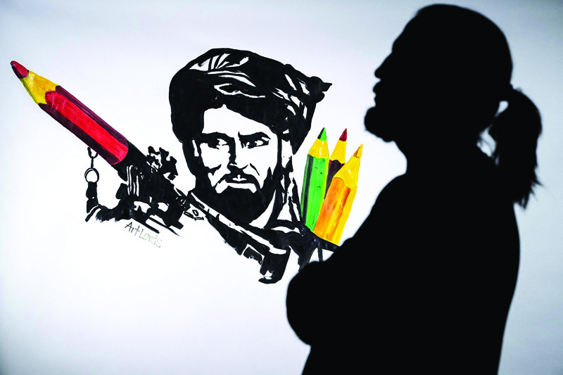 In this file photo Afghan artist and co-founder of the ArtLords collective, Farshad, poses next to a symbolic drawing of his collective, representing a Taliban fighter whose rocket launcher is filled with pencils.—AFP photosn