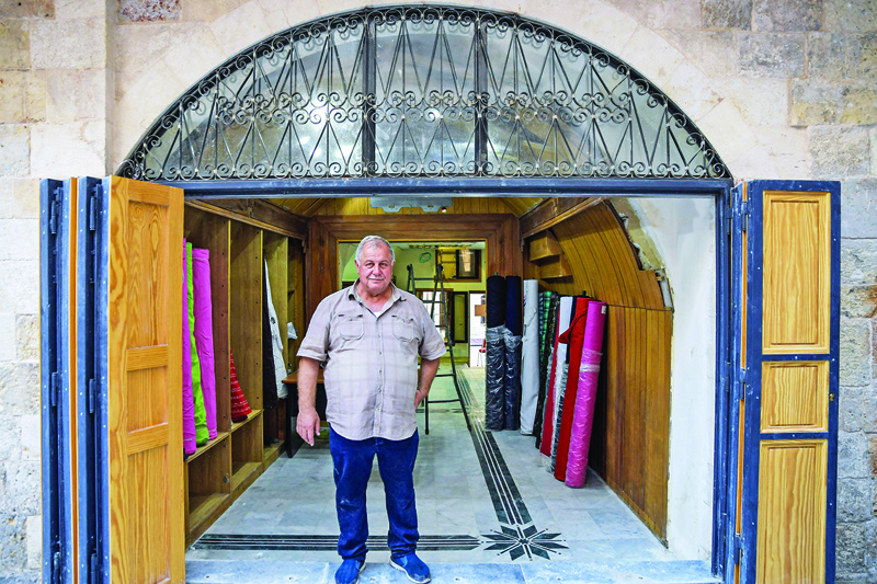 Ahmed Al-Damlakhi, a 65-year-old fabrics merchant, stands outside his shop in the “Souq Khan Al-Harir” (Silk khan covered market) in Syria’s northern city of Aleppo.—AFP photosn