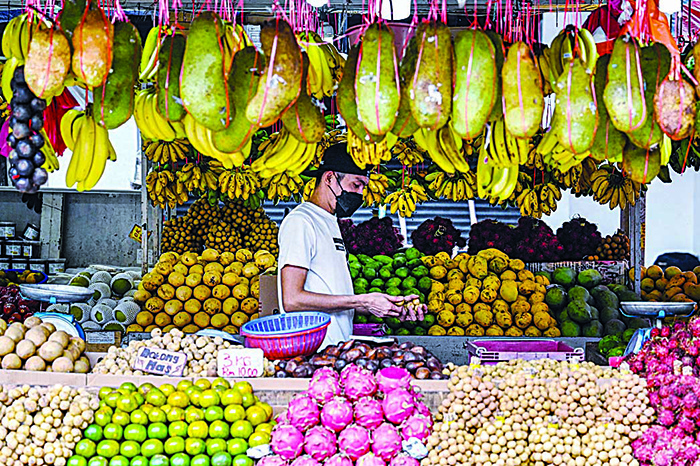 KUALA LUMPUR: A vendor waits for customers at his fruits stall in Kuala Lumpur. —AFP
