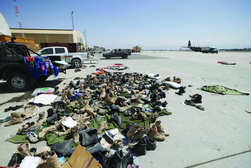 KABUL: Footwear is seen piled up on the tarmac at the airport in Kabul yesterday. - AFP n