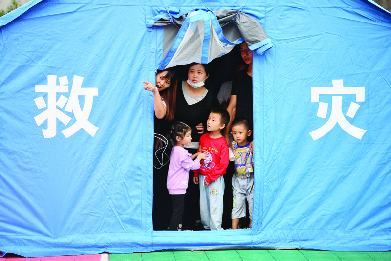 LUZHOU, China: Residents look out from a tent set up for people displaced by a 5.4 earthquake that killed three and injured a dozen in Luzhou, in China's southwestern Sichuan province yesterday.-AFPnn
