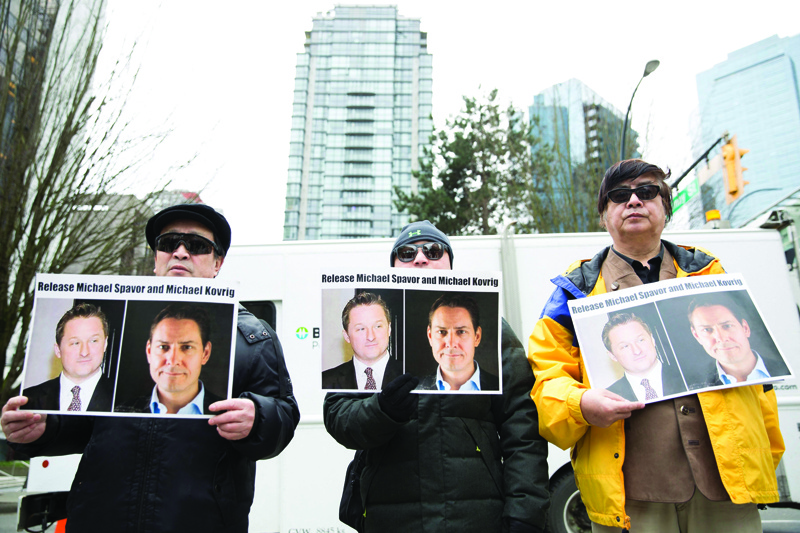 VANCOUVER:  In this file photo, protesters hold photos of Canadians Michael Spavor and Michael Kovrig, who are being detained by China, outside British Columbia Supreme Court in Vancouver. Two Canadians imprisoned in what China's Western critics branded 'hostage diplomacy' headed home September 24, 2021, after being released. - AFP n