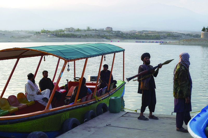 QARGHAH: A Taleban fighter carrying a rocket propelled grenade (RPG) launcher stands on a dock for leisure boats at Qargha Lake on the outskirts of Kabul. - AFP n