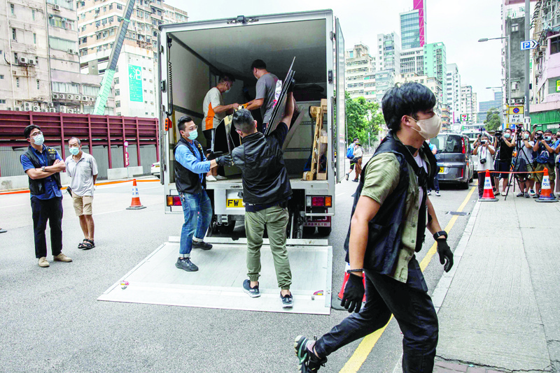 HONG KONG: Police officers (center) from the National Security Department take away items after raiding the June 4 museum dedicated to the 1989 Tiananmen Square crackdown in Hong Kong yesterday. - AFP n