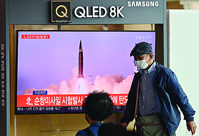 SEOUL: People watch television news broadcast showing file footage of a North Korean missile test, at a railway station in Seoul yesterday after North Korea fired two ballistic missiles into the sea according to the South's military. - AFP n