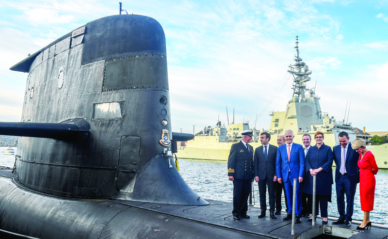 SYDNEY: A file photo shows French President Emmanuel Macron (second left) and Australian Prime Minister Malcolm Turnbull (center) standing on the deck of HMAS Waller, a Collins-class submarine operated by the Royal Australian Navy, at Garden Island in Sydney. - AFPn