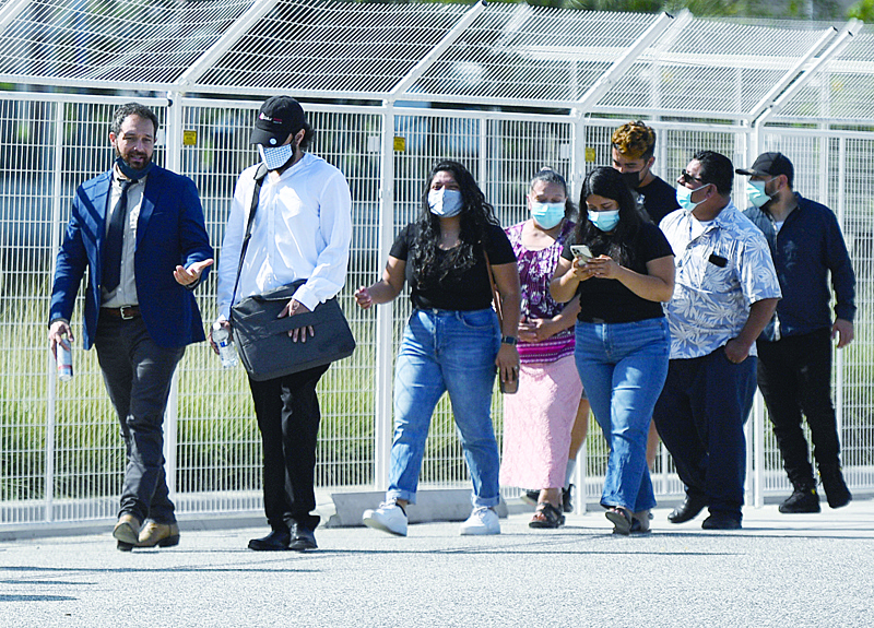 INGLEWOOD, US:  People wear face masks as they wait in line to attend a job fair for employment with SoFi Stadium and Los Angeles International Airport employers, at SoFi Stadium in Inglewood, California. - AFPn