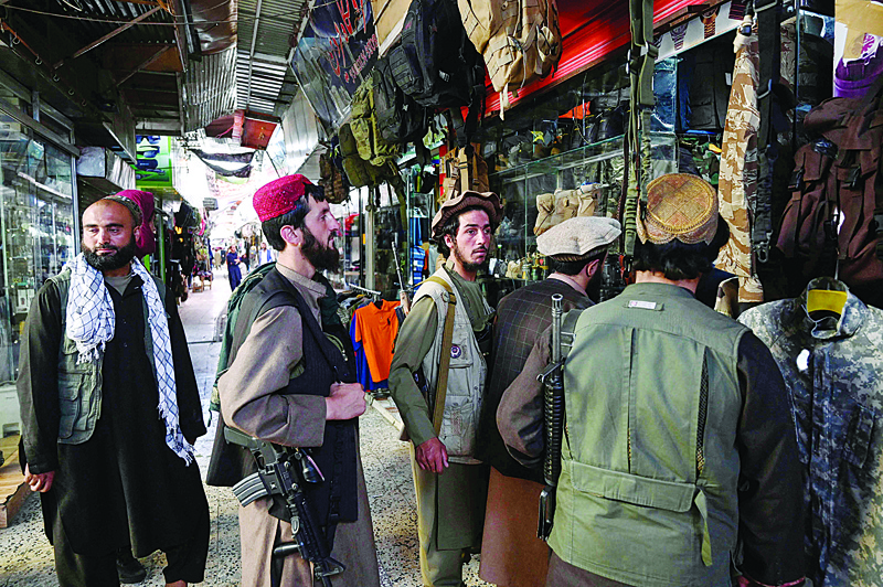 KABUL: Taleban fighters shop at Bush market in Kabul yesterday. - AFPn