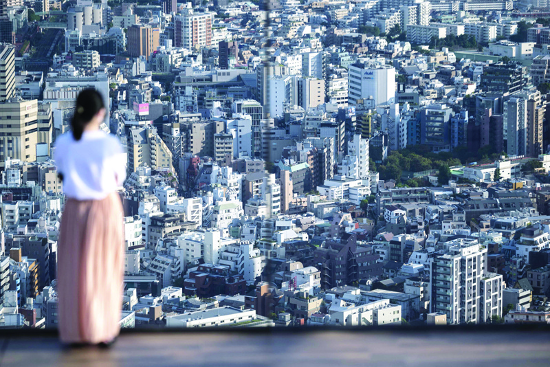 TOKYO: A woman looks out from an observatory deck in Tokyo yesterday. - AFP n