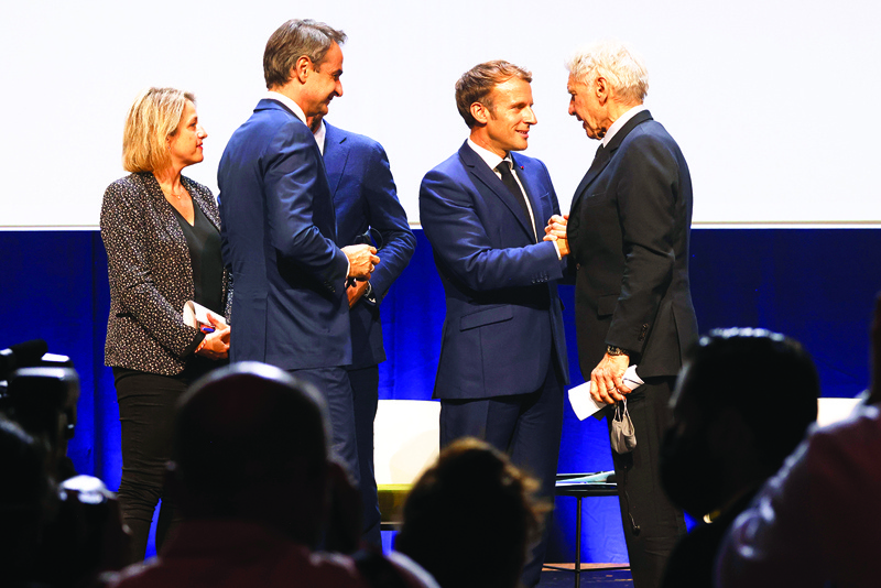MARSEILEE: French President Emmanuel Macron (center) shakes hands with US actor Harrison Ford (right) during the IUCN World Conservation Congress Sunday.-AFPnn