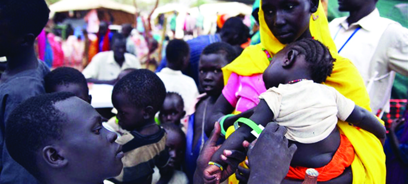 In this file photo, refugee mothers from Sudan's Blue Nile State wait at a clinic in South Sudan to have their children measured for malnutrition and to vaccinate them against measles.n