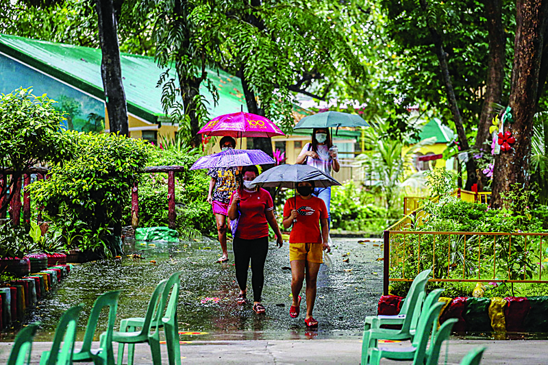 MANILA: Adults arrive to pick up distance learning materials for their children at a school in Quezon City, suburban Manila.-AFPn