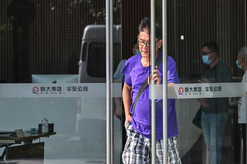 SHANGHAI: People are seen in the Evergrande Center building in Shanghai yesterday.—AFPn