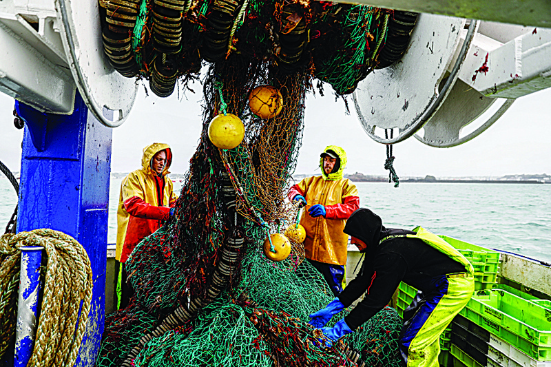 SAINT HELIER, Jersey: In this file photo, French fishermen gather in a net on their vessel near the port of Saint Helier off the British island of Jersey. - AFPnn