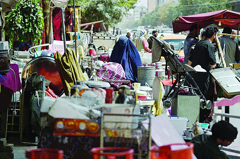 KABUL: Buyers browse second-hand household items for sale at a market in the northwest neighborhood of Khair Khana in Kabul.-AFPn