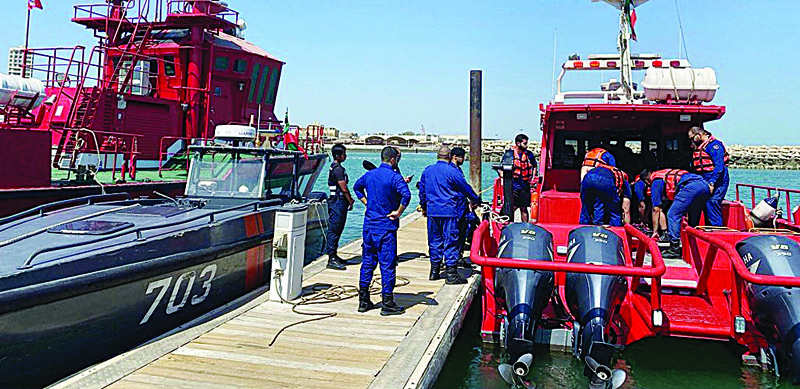 KUWAIT: This handout photo released by Kuwait Fire Force yesterday shows firemen look on as rescuers remove a dead body from a rescue boat shortly after it was recovered from the waters.n