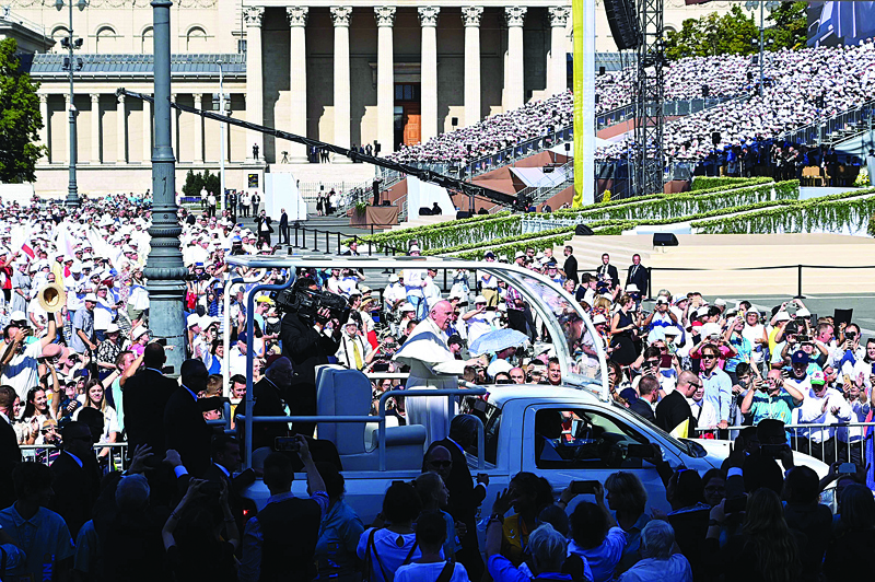 BUDAPEST: Pope Francis greets faithful as he arrives in an open vehicle for a Holy Mass at the end of an International Eucharistic Congress in Budapest yesterday during his papal visit to Hungary. - AFP n