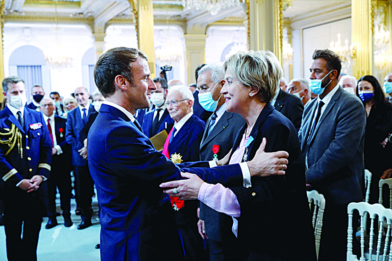 PARIS: Bornia Tarall (center right) is awarded with the 'Chevalier de l'Ordre National du Merite' by French President Emmanuel Macron during a ceremony in memory of the Harkis - Algerians who helped the French Army in the Algerian War of Independence, at the Elysee Palace yesterday. - AFP n