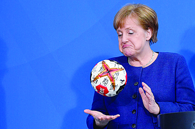 BERLIN:  German Chancellor Angela Merkel plays with a handball given to her by the German Handball Federation's president (not in picture) as she received the German national handball team at the Chancellery in Berlin. - AFP n