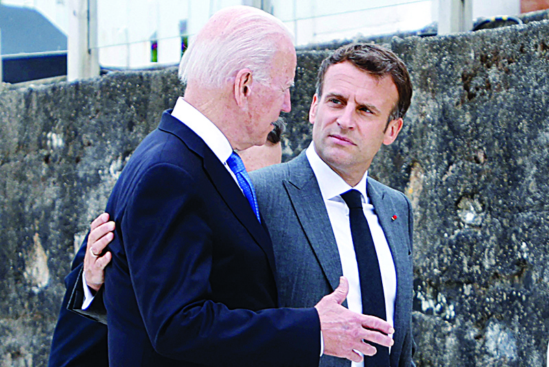 CARBIS BAY: In this file photo US President Joe Biden (left) and France's President Emmanuel Macron speak after the family photo at the start of the G7 summit in Carbis Bay, Cornwall. - AFP n
