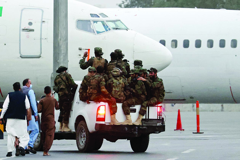 KABUL: Taleban fighters patrol in a vehicle along the tarmac at the airport yesterday. — AFP