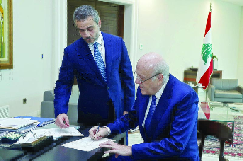 BEIRUT: Prime Minister-designate Najib Mikati signs a decree for the formation of a new Lebanese government after a meeting with the president at the presidential palace in Baabda on Friday. —AFP