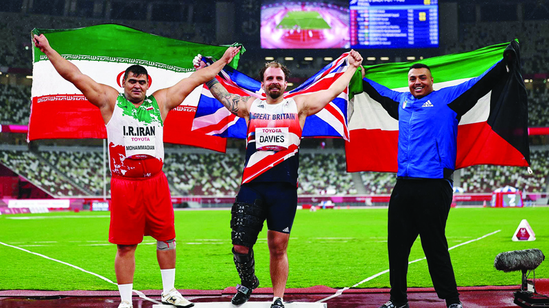 TOKYO: Iran's Sajad Mohammadian (silver) Great Britain's Aled Davies (gold) and Kuwait's Faisal Sorour (bronze) pose after the Men's Shot Put - F63 event at the Summer Paralympic Games yesterday. Ð AFP nn